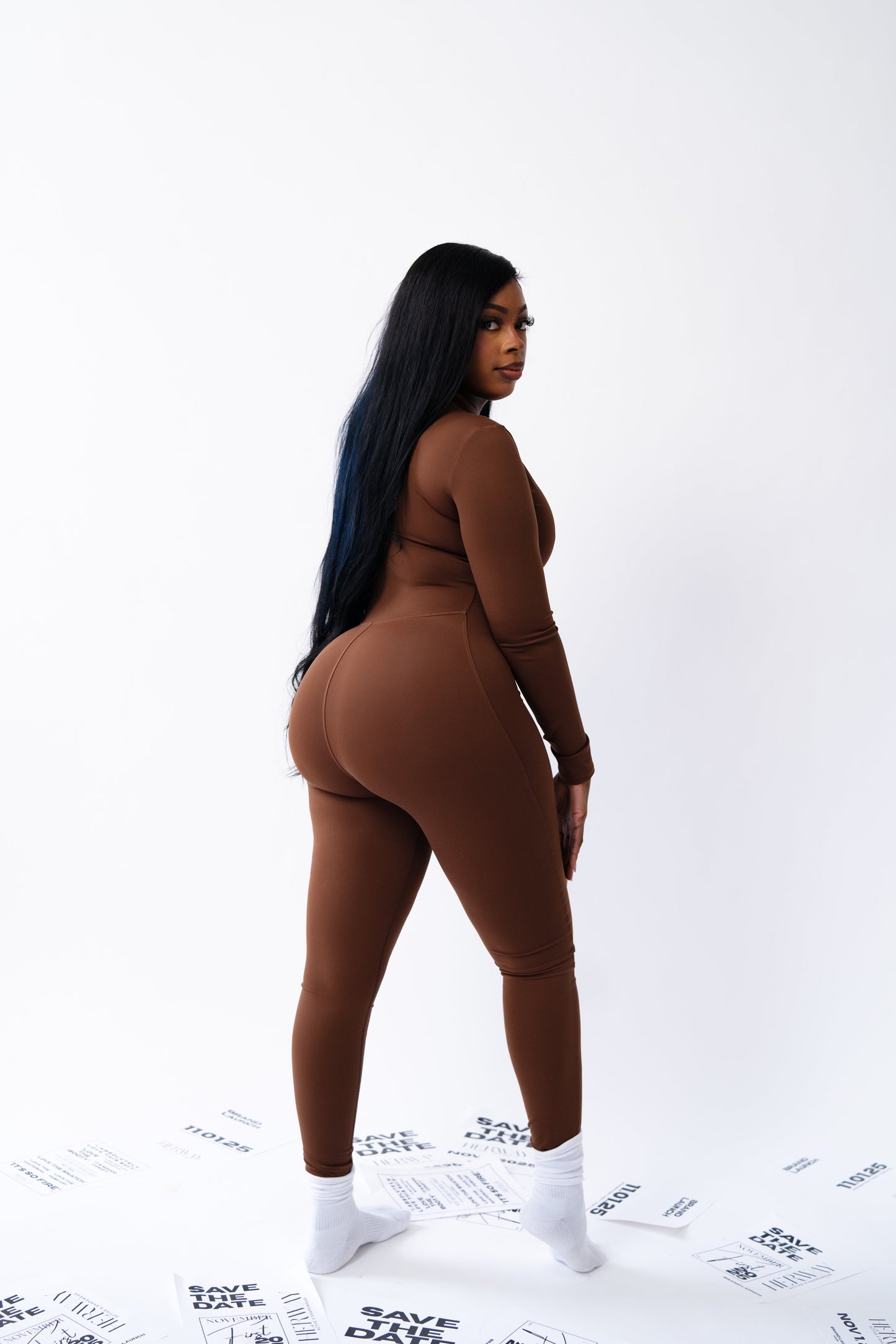Person wearing a brown bodysuit on a white background